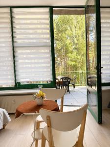 a room with a table and chairs and windows at STUDIO LEŚNE z DUŻYM TARASEM nad Zalewem in Serock