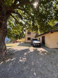 a car parked in front of a building under a tree at Ritrovo Neggia in Vira +10 photos