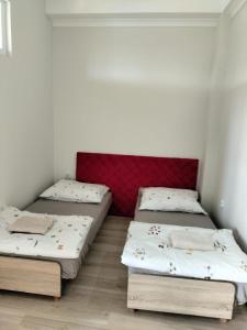 a room with two beds and a red headboard at Pokoje U Cyngla in Mielec