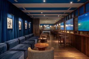 a bar with blue couches and tables and chairs at The Salmar - Adults Only in San Miguel de Abona