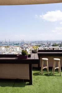 a table with two stools and a view of a city at City Center Apartments in Haifa