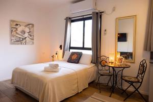 a bedroom with a bed and a table and a mirror at City Center Apartments in Haifa +15 photos