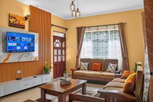 a living room with a couch and a tv at Hakika Homes in Olmotoni