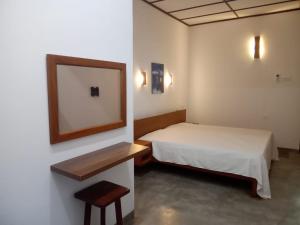a small room with a bed and a mirror at Yara Eleven in Ambalangoda