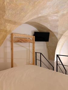 a bedroom with a bed and a tv on a wall at Stella Apartment in Nardò