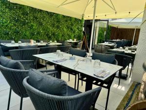a restaurant with tables and chairs and an umbrella at Hotêl - Restaurant Le Bon Duc in Les Billaux
