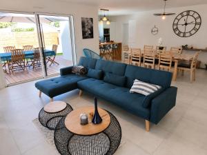 a living room with a blue couch and a table at Le Havre des Dunes in Brem-sur-Mer