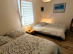 two twin beds in a room with a window at Le Havre des Dunes in Brem-sur-Mer +8 photos