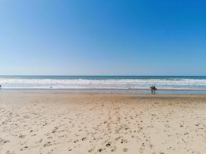 a couple of people walking on the beach at Le Havre des Dunes in Brem-sur-Mer