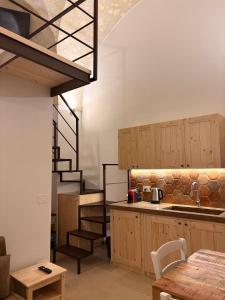 a kitchen with wooden cabinets and a spiral staircase at Stella Apartment in Nardò +10 photos
