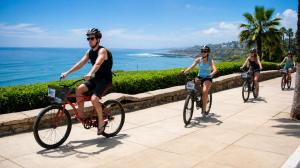 a group of people riding bikes down a path near the ocean at Hotel Soul Mate Inn in Lima