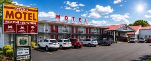 a motel with cars parked in a parking lot at Seely's Motel in Shediac