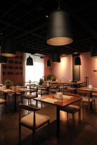 a restaurant with wooden tables and chairs and lights at Terratone Boutique Business Hotel in Kollam