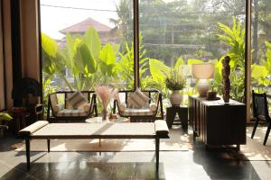 a room with chairs and a large window with plants at Terratone Boutique Business Hotel in Kollam