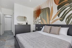 a bedroom with a large bed with a painting on the wall at La Rocca D'amuri - Alma e Aura in Partinico