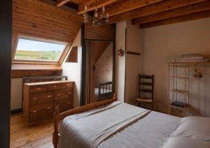 a bedroom with a bed with a dresser and a window at Duplex le Grimpeur - Les Apparts du Sancy in Chastreix