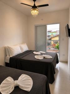 a bedroom with two beds with bows on them at LAAR Hotel in Praia Grande +76 photos