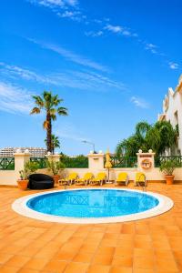 a swimming pool with yellow chairs and a blue sky at Grand Muthu Forte do Vale in Albufeira +50 photos