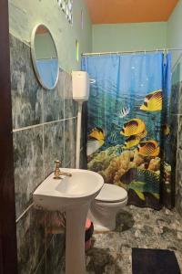 a bathroom with a fish shower curtain and a toilet at Mermaid House, kitchen, Wi-Fi, parking, centre 5 minutes on foot and near Sunset Dune in Aracati +44 photos