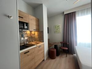 a kitchen with wooden cabinets and a counter top at Hôtel Le Français in La Flotte +60 photos