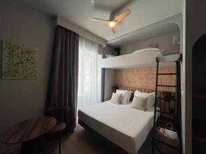 a bedroom with a bunk bed with a ceiling fan at Hôtel Le Français in La Flotte