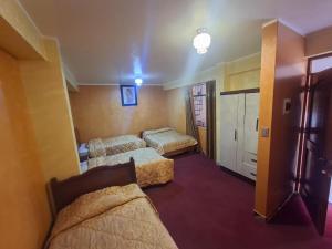 a hotel room with three beds in a room at Hotel La Reserva INN in Ayacucho +15 photos