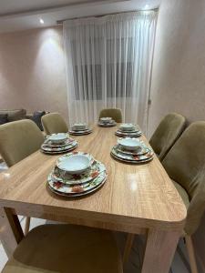 a wooden table with plates and dishes on it at Apartment with pool in Asilah