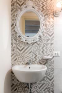 a bathroom with a sink and a mirror on a wall at Rondinelle by Palazzo Refolo in Martano