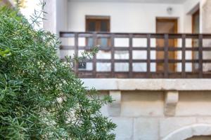 a tree in front of a building with a balcony at Rondinelle by Palazzo Refolo in Martano