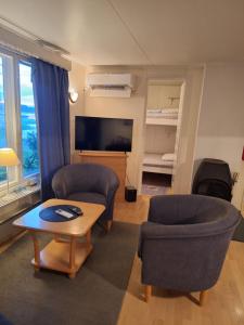 a living room with two chairs and a television at Aijas Semesterstugor in Vaasa
