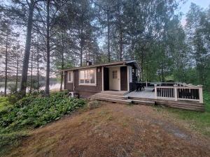 a small cabin in the woods with a porch at Aijas Semesterstugor in Vaasa
