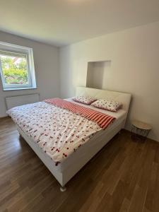 a bedroom with a large bed with red and white sheets at Villa Kraker in Muta