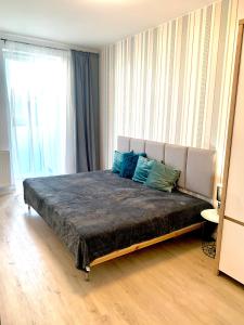 a bedroom with a large bed with blue pillows at Apartament z widokiem na las in Tychy