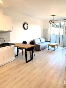 a kitchen and living room with a table and a couch at Apartament z widokiem na las in Tychy