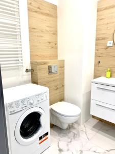 a bathroom with a washing machine and a toilet at Apartament z widokiem na las in Tychy