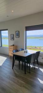 a table and chairs in a room with a large window at Bygghamar in Stykkishólmur