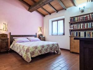 a bedroom with a bed and a book shelf with books at Holiday Home Luce by Interhome in Dicomano