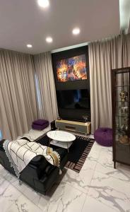 a living room with a large flat screen tv at Villa with the red pool in Hinkong