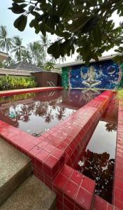 a pool of water with a red tiled floor at Villa with the red pool in Hinkong
