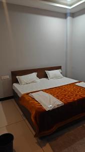 a bedroom with a large bed with a wooden headboard at Hotel Trilok in Ujjain