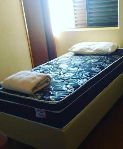 a bed with two pillows on top of it at Hotel Teixeira in Rio Verde