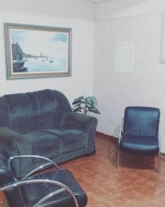 a living room with a couch and a chair at Hotel Teixeira in Rio Verde