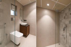 a bathroom with a toilet and a glass shower at Morya Villa - A Boutique Hotel in kolkata +29 photos