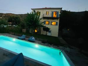 a swimming pool in front of a house at night at Private Swimmingpool in Cottage in Poros