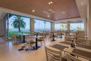 a restaurant with tables and chairs and a view of the ocean at Hotel Puerto Bahía & Spa in El Puerto de Santa María