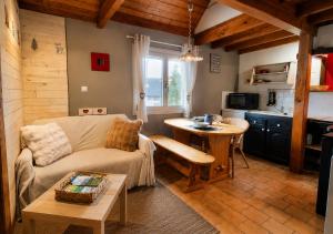 a living room with a couch and a table at Duplex le Grimpeur - Les Apparts du Sancy in Chastreix