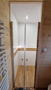 a walk in shower in a room with wooden walls at Fraseryja domek w Bieszczadach in Bukowiec +16 photos