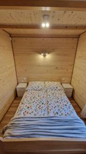 a bedroom with a bed in a wooden room at Fraseryja domek w Bieszczadach in Bukowiec