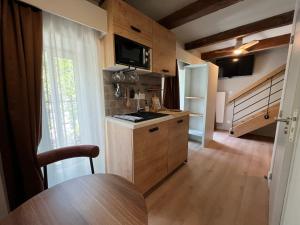 a small kitchen with a table and a refrigerator at Hôtel Le Français in La Flotte
