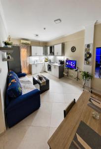 a living room with a blue couch and a kitchen at CS apartment Patra in Patra